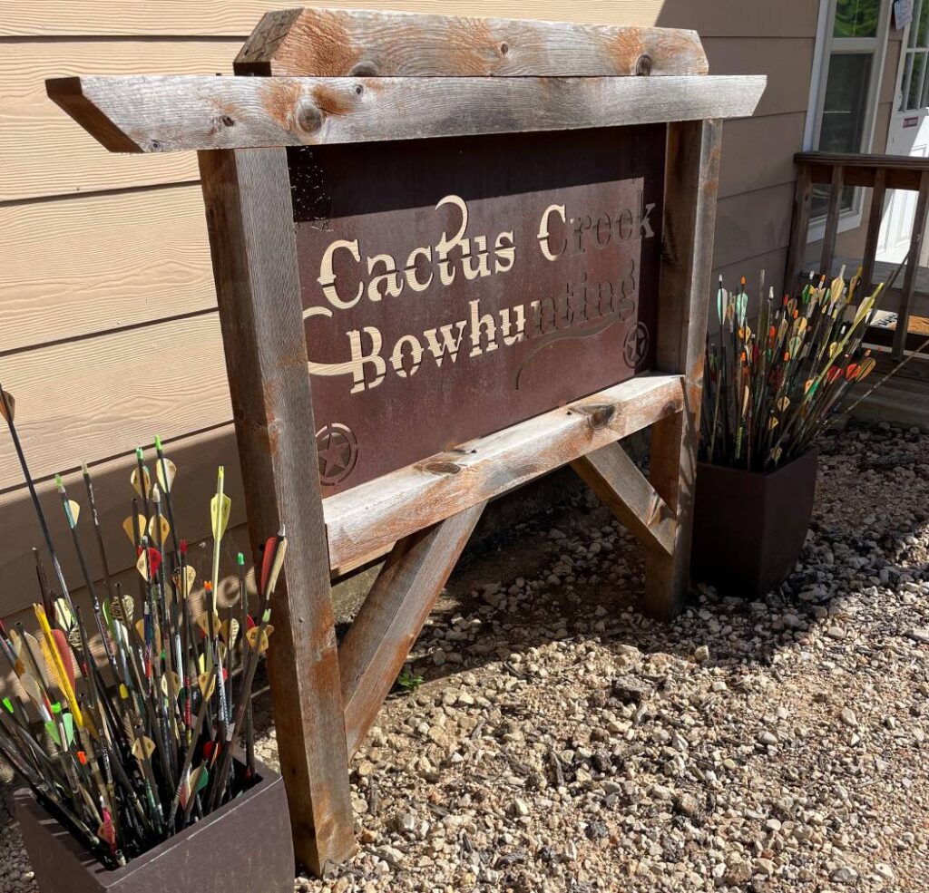 Rustic-themed name plate with the inscription Cactus Creek Bow Hunting